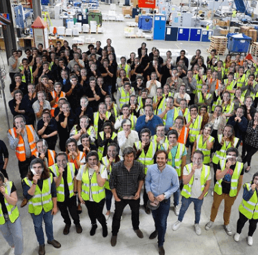 instantprint founders Adam and James surrounded by their employees in the factory